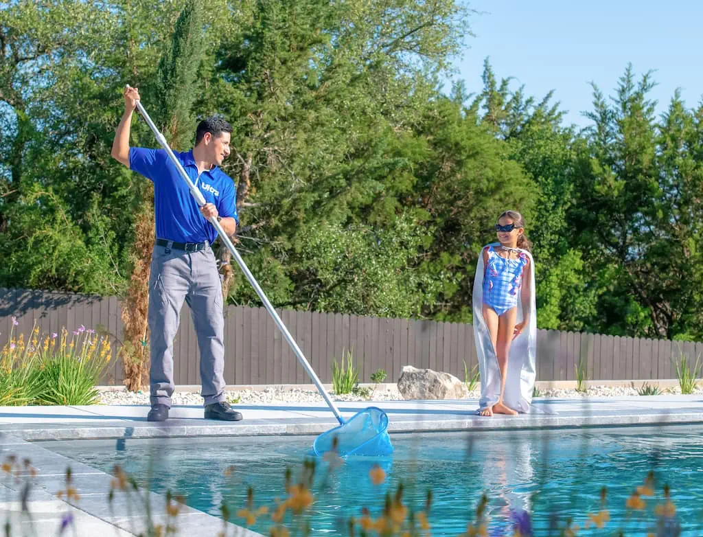 An Ultra Pool Care Squad Franchise technician cleaning a swimming pool